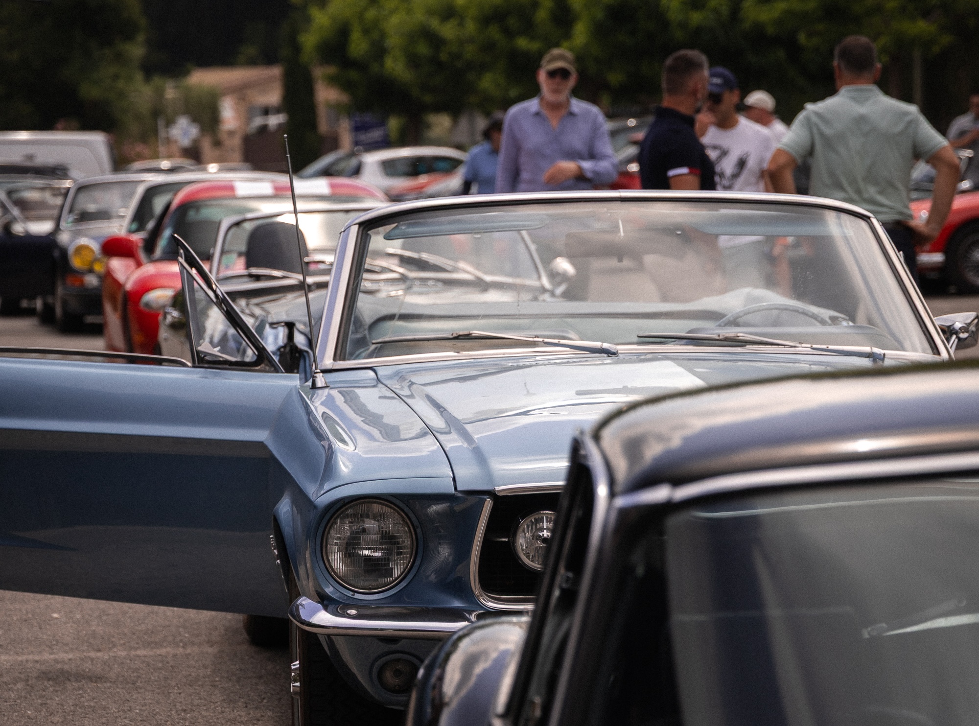Participants réunis autour de voitures classiques pendant un incentive